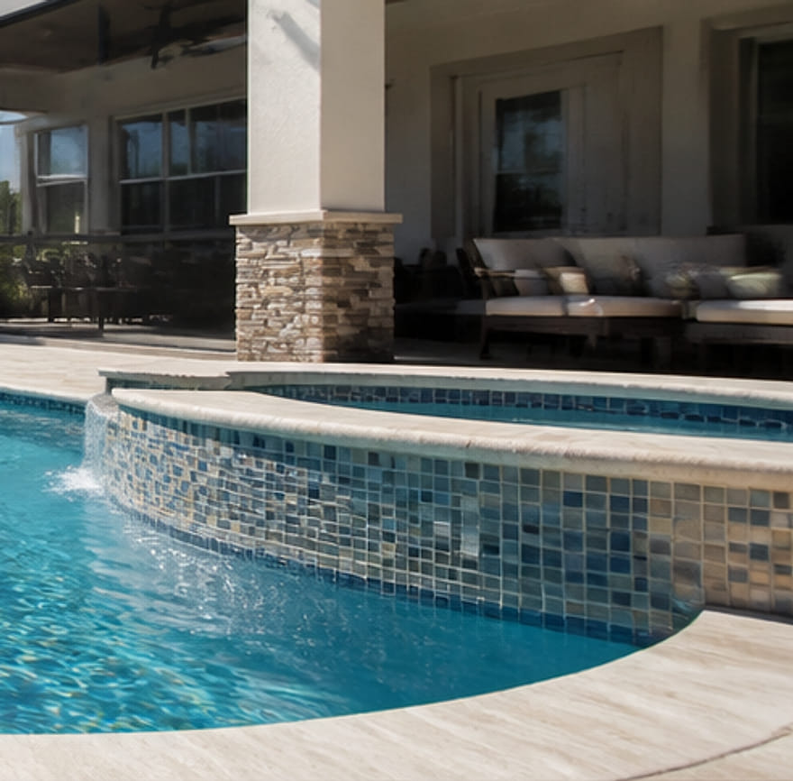 Raised spa with glass mosaic tile spilling over into the pool.